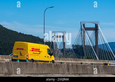 Vigo, Pontevedra, 6.18.2024; furgone per la consegna di pacchi con l'immagine della società DHL che circola sull'autostrada che attraversa il ponte Rande a Vigo. Foto Stock