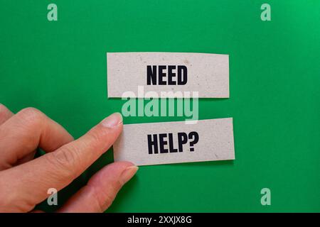 Messaggio di domanda di assistenza scritto su fogli di carta con sfondo verde. Simbolo della domanda di aiuto concettuale. Copia spazio. Foto Stock
