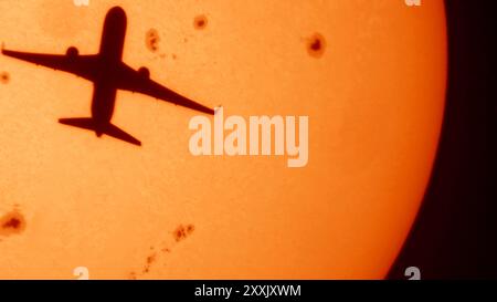 Londra, Regno Unito. 25 agosto 2024. Sole a Londra all'inizio di una settimana di caldo dopo una giornata di pioggia. Un aereo in partenza da Heathrow vola di fronte al sole e a numerose macchie solari. Crediti: Malcolm Park/Alamy Live News Foto Stock