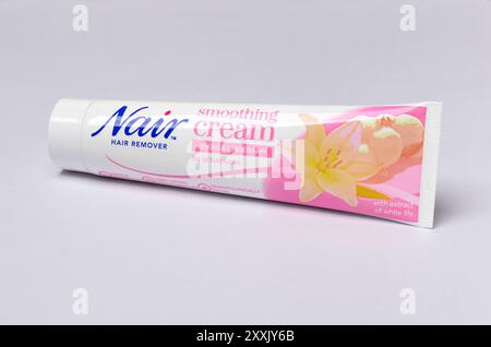 Tubo della crema lenitiva per la rimozione dei capelli Nair per bikini e l'estratto ascellare del giglio bianco su sfondo bianco Foto Stock