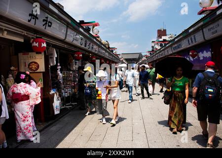 I viaggiatori giapponesi viaggiano visitando negozi selezionati e compra souvenir sulla via dello shopping Shin Nakamise dori, mercato di antiquariato locale di Asakusa a Ta Foto Stock