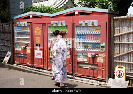 Viaggiatore donna giapponese indossa abiti tradizionali kimono viaggio visita acquistare distributore automatico di bevande acquatiche sulla via dello shopping Shin Nakamise dori Foto Stock