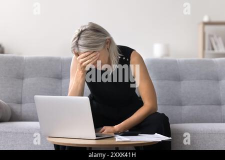 Donna matura depressa per preoccupazioni finanziarie e debiti Foto Stock