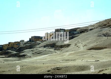 La vista da un autobus rivela antiche rovine a Deir el Bahri, situata nella Valle delle Regine. Il cielo luminoso e il paesaggio mettono in risalto l'istore Foto Stock