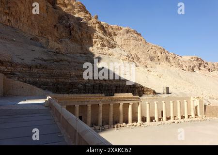 Le rovine del Tempio Mortuario di Hatshepsut si stagliano nel paesaggio desertico di Deir el-Bahri, con torreggianti colonne che riflettono l'antico architec egiziano Foto Stock