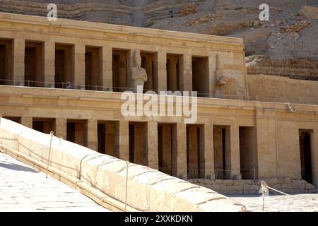 Il Tempio Mortuario di Hatshepsut si erge maestosamente a Deir el Bahri, mostrando l'antica architettura tra paesaggi desertici. I visitatori esplorano il Foto Stock