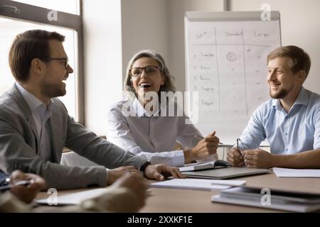 Gruppo di professionisti impegnati in discussioni vivaci e positive Foto Stock