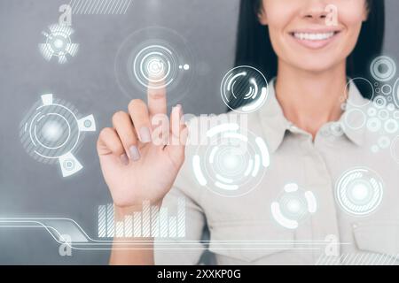 Tecnologie futuristiche. Immagine ritagliata di una giovane donna che tocca lo schermo trasparente e sorride Foto Stock