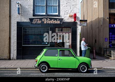 Cliente che fuma fuori dal bar Victoria in High Street, Elgin, Moray, Scozia, Regno Unito. Foto Stock