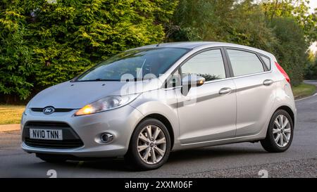 Whittlebury, Northants., Regno Unito - 25 agosto 2024: Auto Ford Fiesta d'argento 2010 che guida su una strada di campagna britannica. Foto Stock