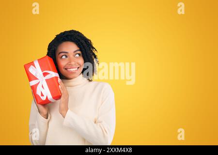 Sorridente americano africano donna scuotendo anno nuovo dono Foto Stock