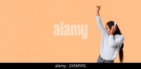 Joyful Young Woman Dancing mentre ascoltano musica Foto Stock