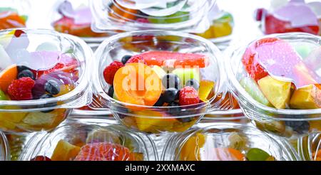 Scatole di plastica con macedonie di frutta preconfezionate, messe in vendita in un frigorifero commerciale Foto Stock