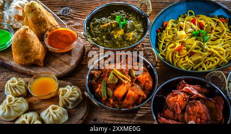 Composizione con piatti indiani: samosa, pakora, paneer di palak, jalfrezi, thukpa e pane naan Foto Stock