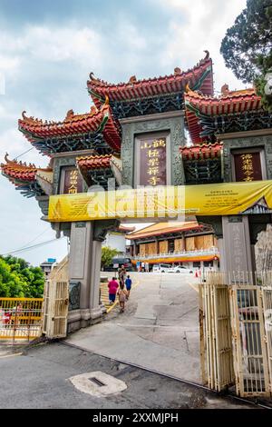 Una grande porta orientale si estende su una strada che porta al tempio Tek Lok si a Penang, Malesia Foto Stock