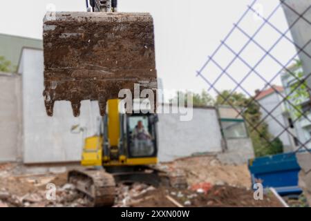 Grande escavatore è il riempimento di un dumper con terreno in corrispondenza del sito di costruzione, il progetto in corso. Foto Stock