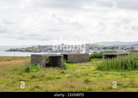 I resti di una batteria antiaerea della seconda guerra mondiale sulla collina di Cruester sull'isola di Bressay, Shetland. Con Lerwick sulle Shetland Mainland sullo sfondo. Foto Stock