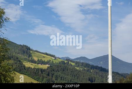 Eben im Pongau, Salisburgo - Austria. La vista rivela il pittoresco altopiano alpino con splendide case, alberi lussureggianti e prati verdeggianti. Foto Stock