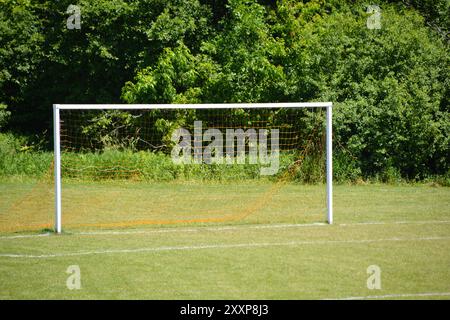 Gol da calcio bianco su un campo sportivo vuoto prima di una partita in una giornata estiva. Foto Stock