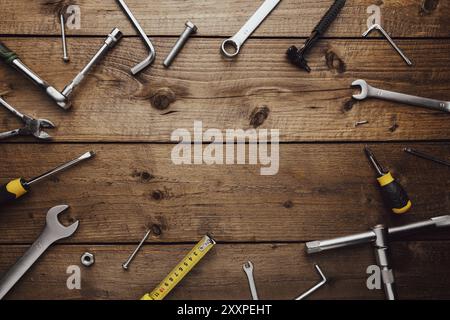 Giacitura piatta con varie attrezzature su piano di lavoro in legno. Vista dall'alto sul nuovo set di attrezzi manuali per riparazione, kit di costruzione, sospeso. Da non perdere f Foto Stock