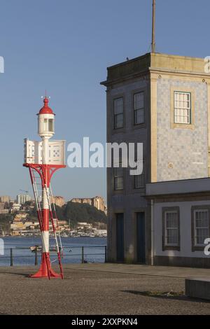 Faro di Farolim da Cantareira di fronte alla facciata storica della Capela-Farol de Sao Miguel-o-Anjo alla luce della sera sul lungomare Foto Stock