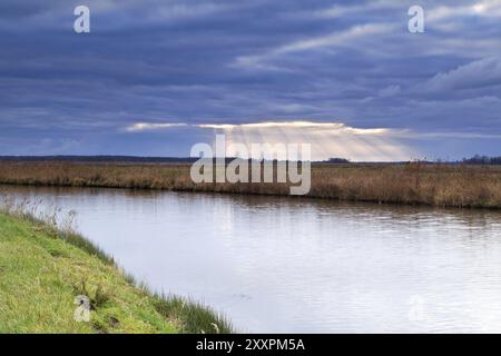 Raggi di sole attraverso il cielo nuvoloso durante la tempesta sul canale Foto Stock