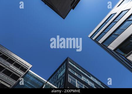 Si affacciano su alti e moderni edifici per uffici in cemento vetro e acciaio Foto Stock