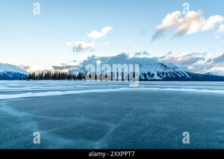 Incredibili montagne innevate in inverno con un lago ghiacciato in primo piano. Presa ad Atlin, Columbia Britannica, vicino all'Alaska, territorio dello Yukon. Foto Stock