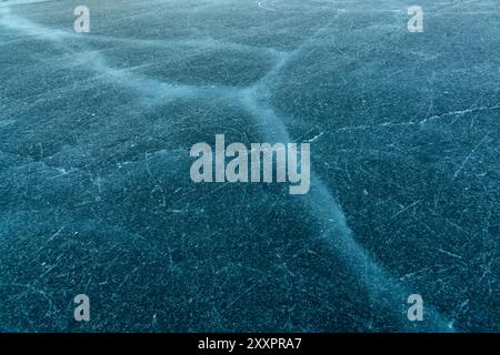 Primo piano di un lago ghiacciato in inverno in Canada con crepe viste in un bel ghiaccio. Foto Stock