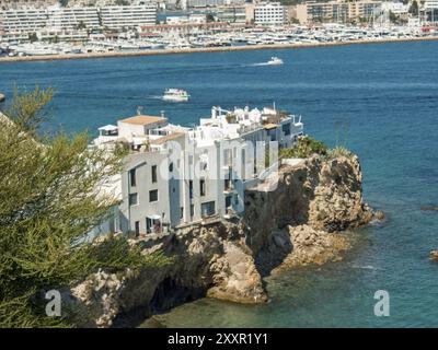 Case bianche su una scogliera vicino al mare, che si affaccia su una parte del porto, ibiza, mediterraneo, spagna Foto Stock