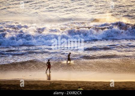 Un gruppo di giovani uomini che si divertono sulla spiaggia Foto Stock