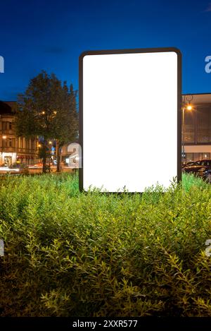 Mockup vuoto di Billboard at Night. Supporto per schermo pubblicitario in Un Bush Foto Stock