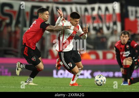 Buenos Aires, Argentina. 25 agosto 2024. Il centrocampista del River Plate Claudio Echeverri (C) si reca per il pallone con il centrocampista uruguaiano dei Newells Old Boy Rodrigo Fernandez Cedres durante il torneo argentino Professional Football League 2024 "Cesar Luis Menotti" allo stadio El Monumental di Buenos Aires, il 25 agosto 2024. Crediti: Alejandro Pagni/Alamy Live News Foto Stock