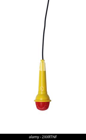 Il microfono giocattolo per bambini è giallo e ha un cavo nero collegato con un cavo isolato su sfondo bianco e con percorsi di ritaglio. Foto Stock