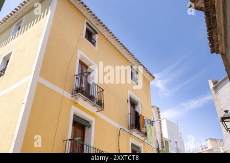Foto della splendida città di Villajoyosa in Spagna che mostra una piccola strada con le case colorate su entrambi i lati del villaggio spagnolo nel summ Foto Stock
