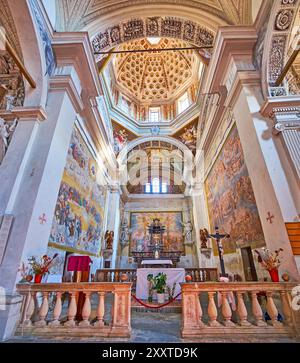 CARONA, SVIZZERA - 22 MARZO 2022: L'abside affrescata colorata, l'altare, le pareti e la cupola della Chiesa parrocchiale di San Giorgio e Sant'Andrea a Carona, Swit Foto Stock