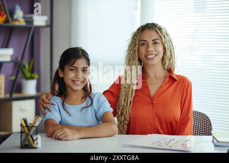 Ritratto di madre e figlia sorridenti che posano in casa Foto Stock