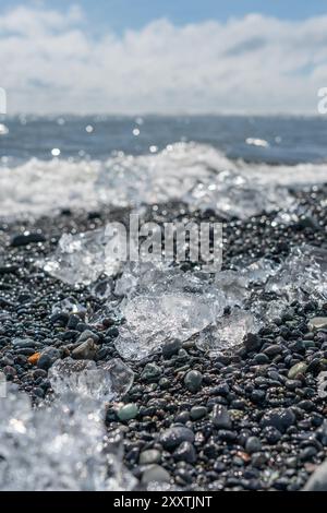 Blocchi di ghiaccio e iceberg rotti su una spiaggia vulcanica di sabbia nera a Diamond Beach in Islanda Foto Stock