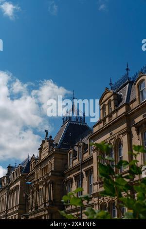 EDIMBURGO - 28 LUGLIO 2024: La splendida architettura accanto al Museo Nazionale di Edimburgo risplende sotto un cielo azzurro e soffici nuvole. Foto Stock