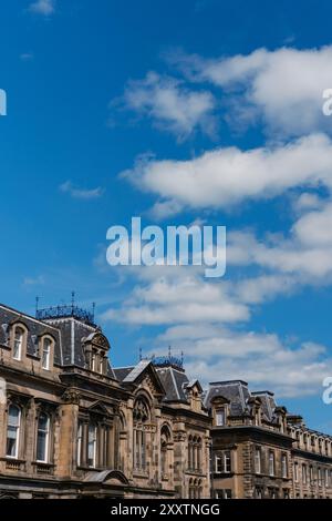 EDIMBURGO - 28 LUGLIO 2024: Splendidi edifici storici che mostrano disegni intricati su un cielo blu brillante. Foto Stock