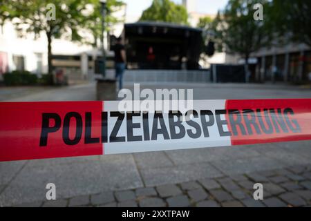 Solingen, Germania. 26 agosto 2024. Nastro di barriera, cordone di polizia sul Fronhof, sullo sfondo il palco vuoto, il cancelliere federale Olaf Scholz, il primo ministro Hendriok Wuest, Wust, il ministro dell'economia Mona Neubaur, il ministro dell'interno Herbert Reul e il sindaco Tim Kurzbach commemorano i tre morti e i diversi feriti sul Fronhof di Solingen, presumibilmente uccisi da un siriano di 26 anni venuto in Germania come migrante, Solingen, 26 agosto 2024 Foto Stock