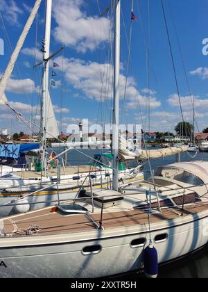 Timmendorf - Island Poel - Germania - barca a vela nella Marina con faro sullo sfondo in una giornata di sole Foto Stock