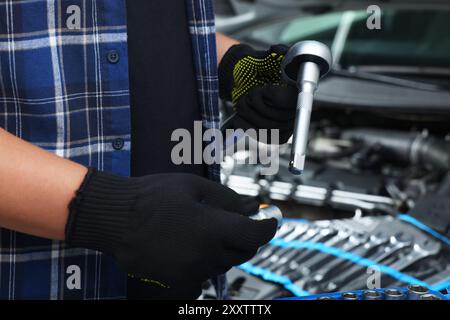 Meccanico automatico con chiave dinamometrica presso l'officina di riparazione di automobili, primo piano Foto Stock