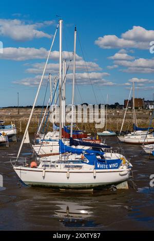 EDIMBURGO - 28 LUGLIO 2024: Le barche a vela sono ancorate in un tranquillo porto di Fisherrow, circondato da cieli azzurri e soffici nuvole bianche. Foto Stock