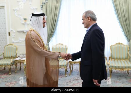 Teheran, Iran. 26 agosto 2024. Il presidente iraniano MASOUD PEZESHKIAN (R) e il primo ministro e ministro degli Esteri del Qatar Sheikh MOHAMMED BIN ABDULRAHMAN BIN JASSIM AL THANI (L) si stringono la mano all'inizio della riunione a Teheran. Il primo ministro del Qatar è a Teheran per incontrare i funzionari iraniani sulle tensioni tra Iran e Israele. (Immagine di credito: © Presidenza iraniana tramite ZUMA Press Wire) SOLO USO EDITORIALE! Non per USO commerciale! Crediti: ZUMA Press, Inc./Alamy Live News Foto Stock