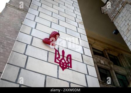 KIEV, UCRAINA - 24 AGOSTO 2024 - la scultura dell'artista di strada francese James Colomina che raffigura un bambino che emerge dal muro dell'ufficio postale principale per dipingere lo stemma ucraino, noto anche come il tridente, è raffigurata a Maidan Nezalezhnosti nel 33° giorno dell'indipendenza dell'Ucraina, Kiev, capitale dell'Ucraina. Foto Stock