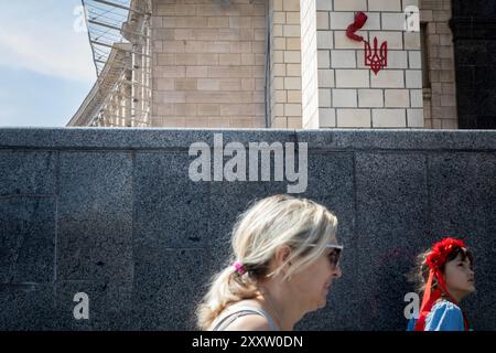 KIEV, UCRAINA - 24 AGOSTO 2024 - la scultura dell'artista di strada francese James Colomina che raffigura un bambino che emerge dal muro dell'ufficio postale principale per dipingere lo stemma ucraino, noto anche come il tridente, è raffigurata a Maidan Nezalezhnosti nel 33° giorno dell'indipendenza dell'Ucraina, Kiev, capitale dell'Ucraina. Foto Stock