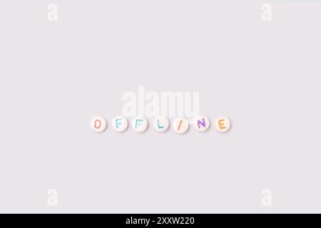 Parola non in linea. Citazione fatta di perline rotonde bianche con lettere colorate su sfondo blu. Concetto di detox digitale. Foto Stock