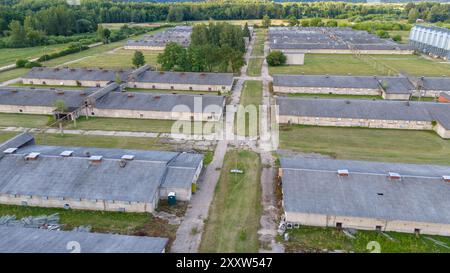 Fotografia con drone di una vecchia fabbrica di polli al coperto durante il giorno nuvoloso estivo Foto Stock