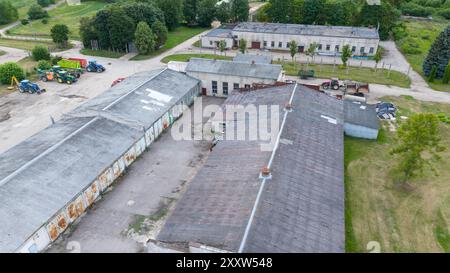 Fotografia con drone di una vecchia fabbrica di polli al coperto durante il giorno nuvoloso estivo Foto Stock